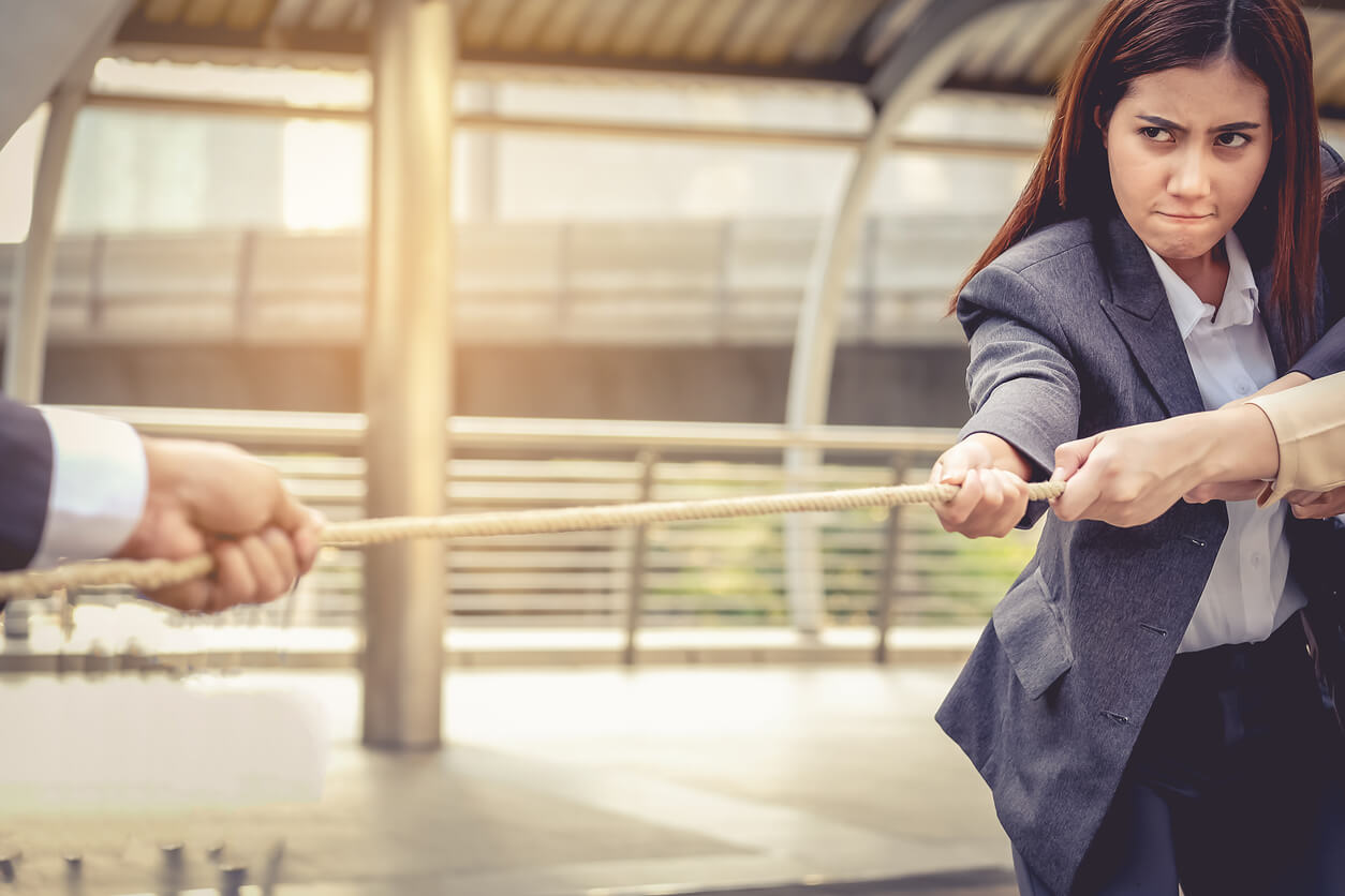 Business women help pull the rope against the business man