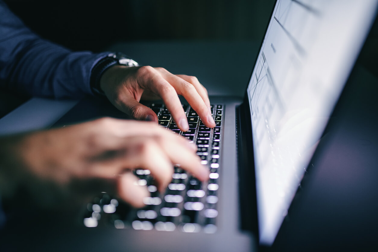 Hands typing on laptop keyboard