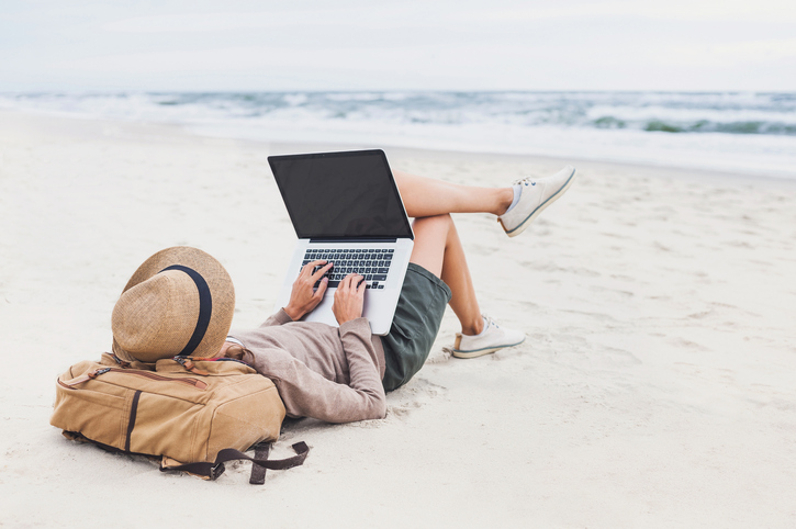 Woman on beach using laptop