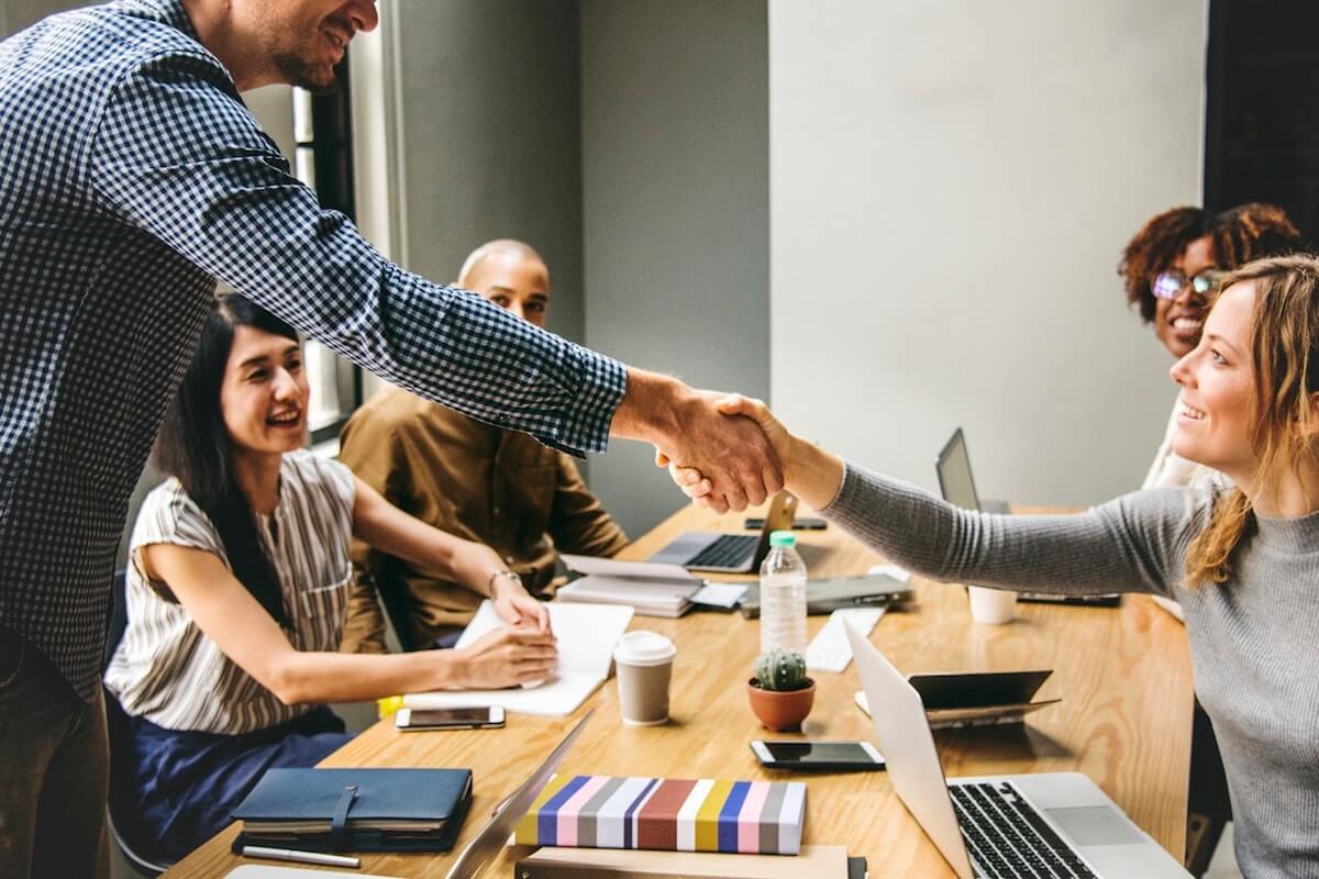 colleagues shaking hands across table