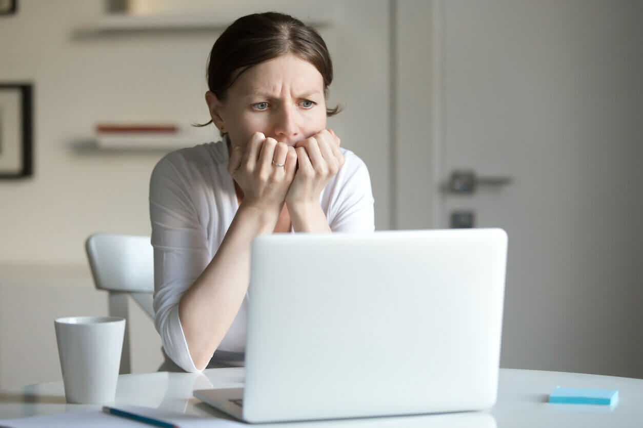 woman behind laptop in fear