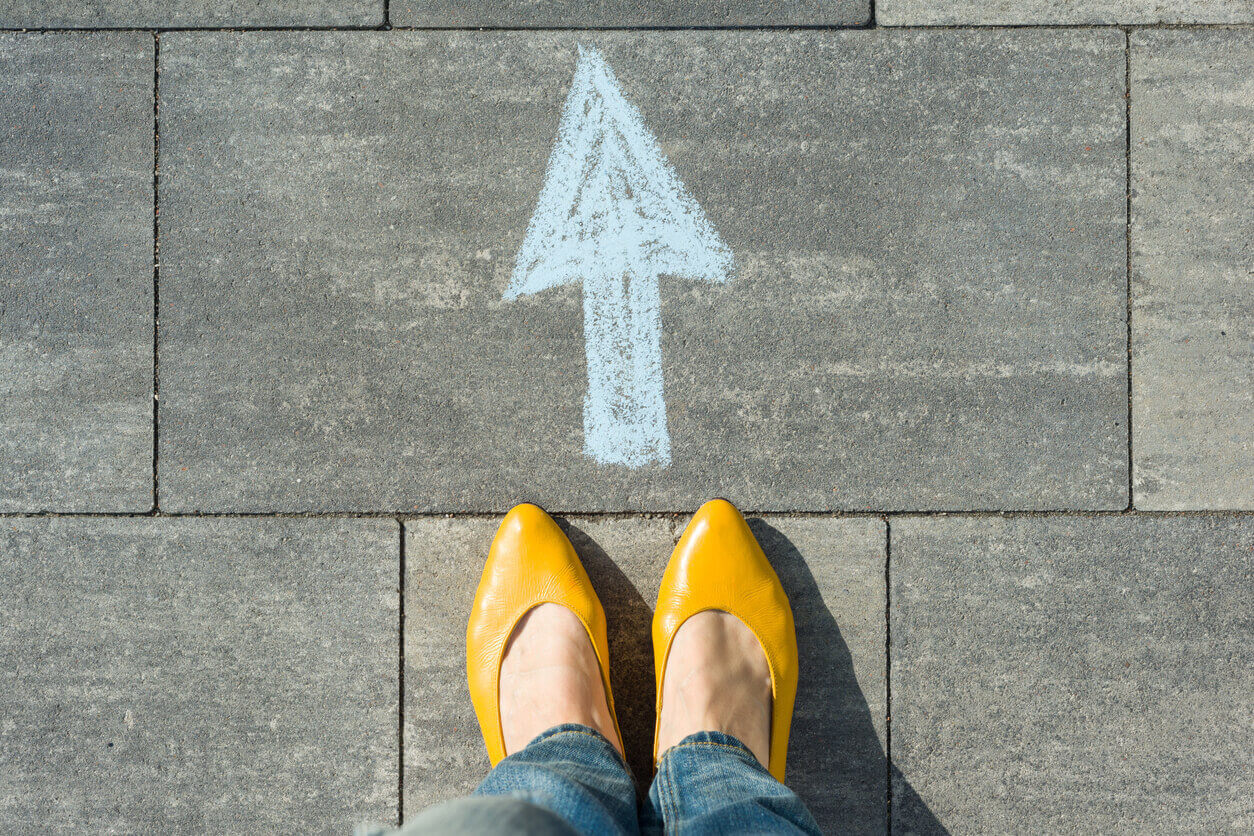 arrow in chalk in front of yellow shoes