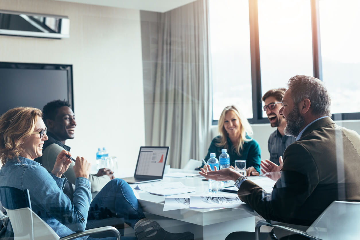 business people laughing around table