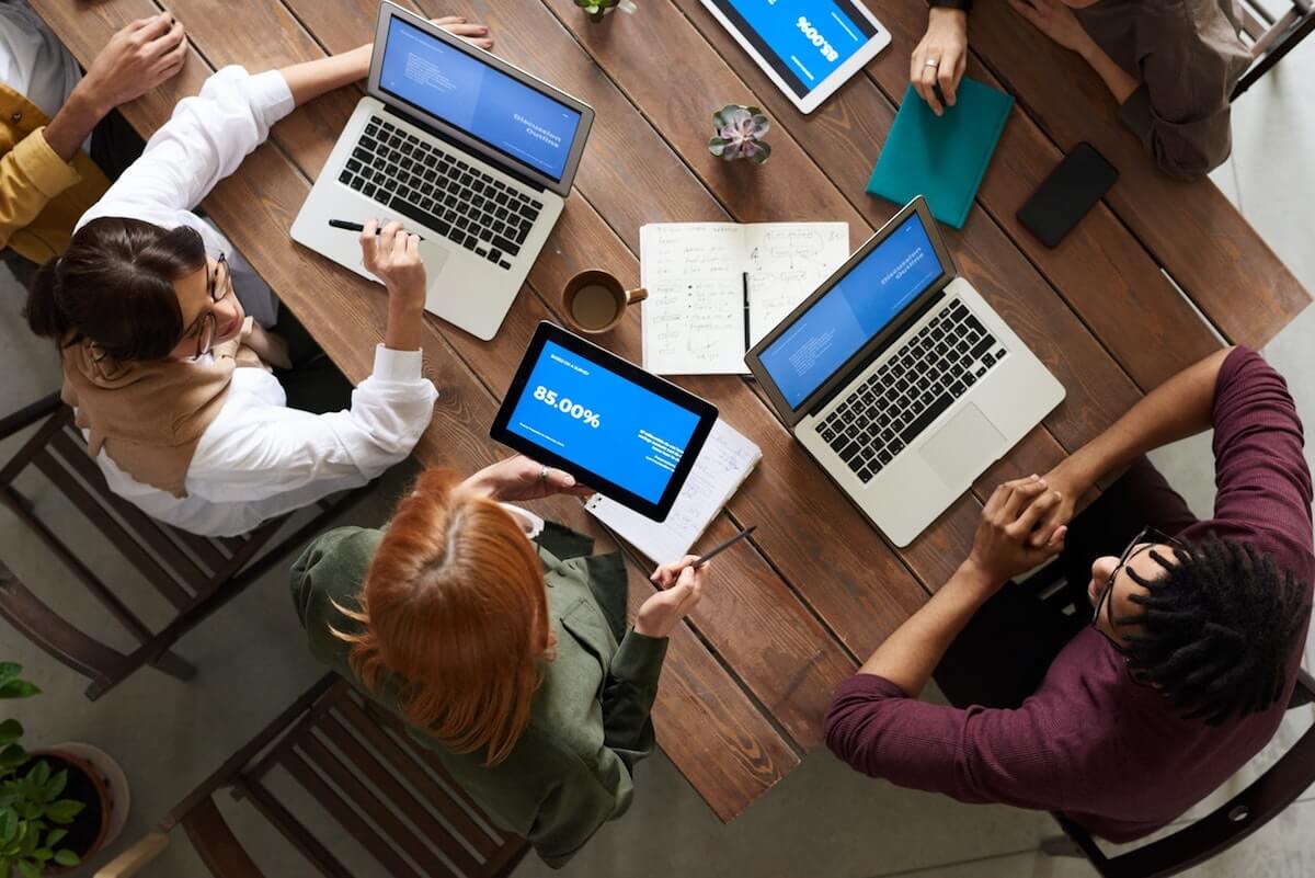 top view photo of group of people using macbook