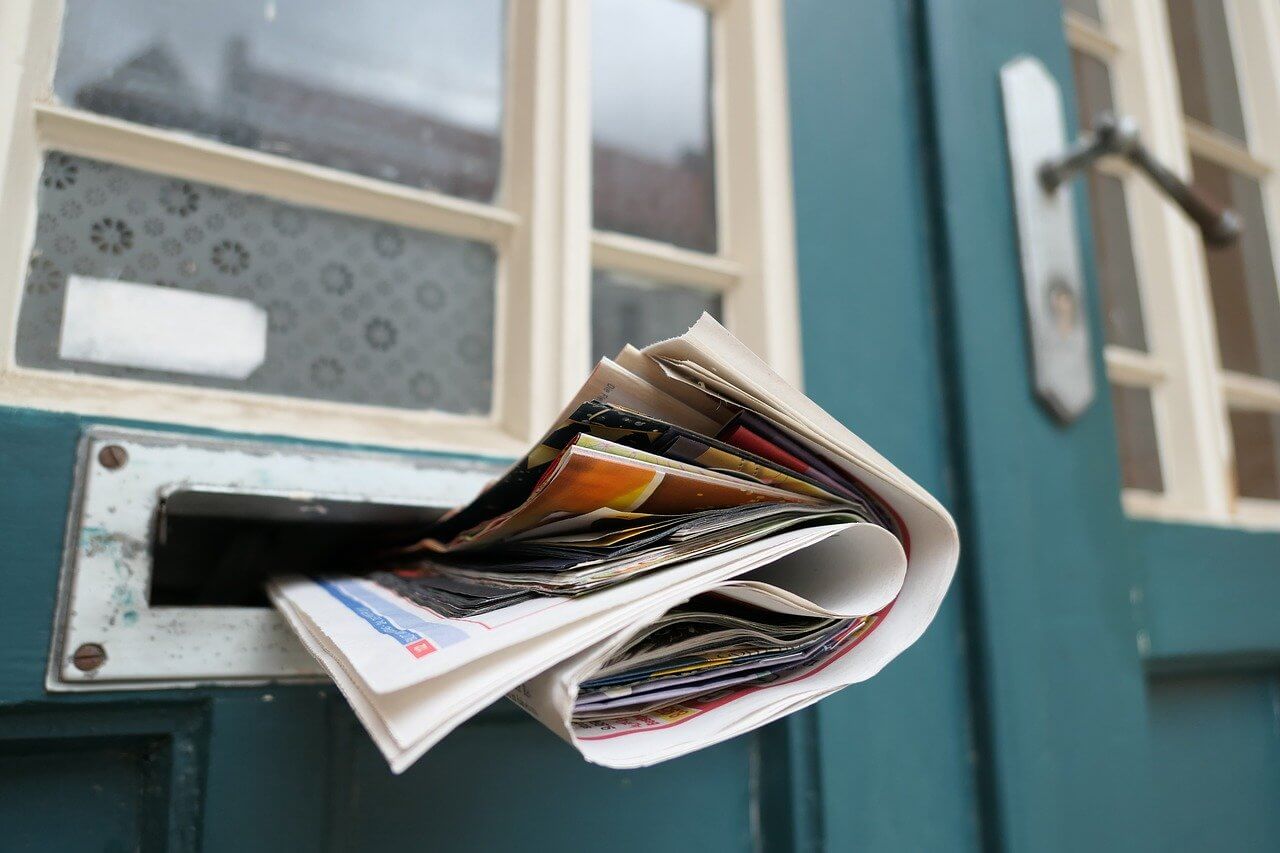 newspaper stuffed in mailbox