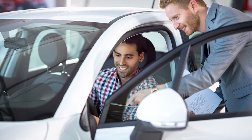 A car dealer showing a car to a customer