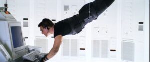 This photo shows Ethan Hunt, the fictional character from the Mission: Impossible series, being lowered from the ceiling to hack a computer. 