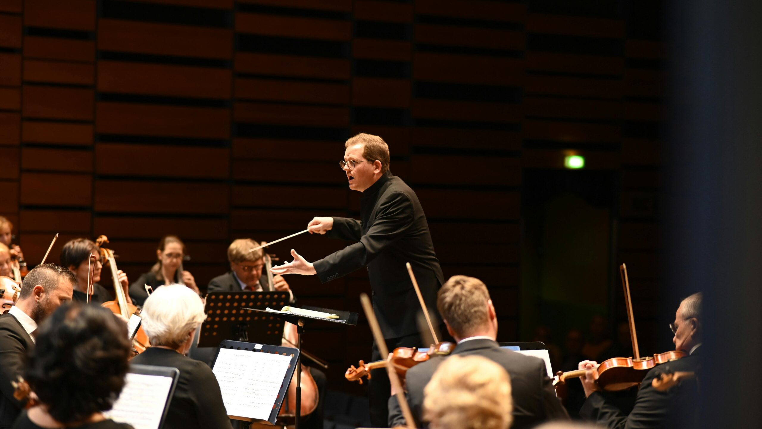 A conductor leading a symphony orchestra. 