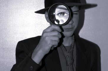 A person looking through a magnifying glass, like a detective
