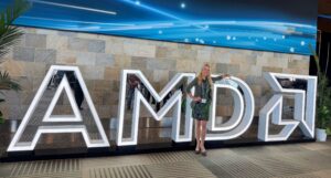 A woman standing in front of large letters that spell AMD
