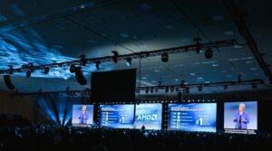 Widescreen shot from back of the room at AMD keynote with CEO Dr. Lisa Soo on stage